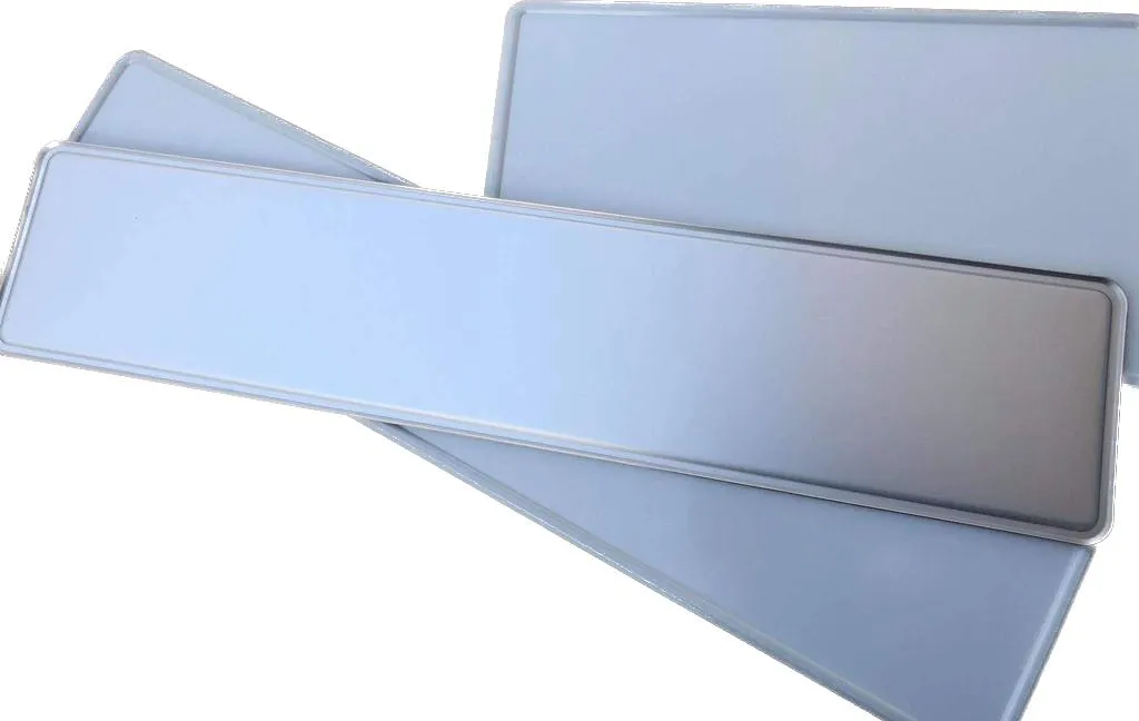 Drei übereinanderliegende, noch unbeprägte Kennzeichenrohlinge aus Aluminium